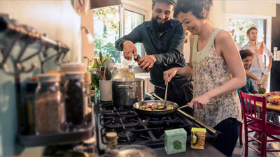 Couple in kitchen cooking