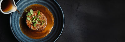 Pouring sauce on fine dining dish in bowl