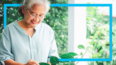Elderly woman on terrace with lush greenery