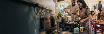 Couple in kitchen cooking