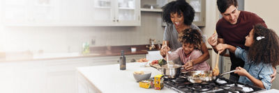 Family cooking dinner, ready-made sauces in Tetra Recart carton packages