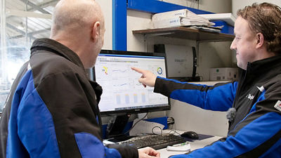 Farmers looking at data on computer screen