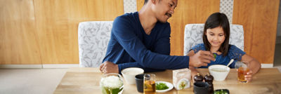 Father and daughter eating soup
