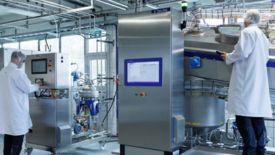 People in production beside machines for fermentation