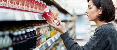 Woman in store looking at healthy-beverages on shelf