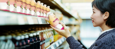 Woman in store looking at healthy-beverages on shelf