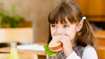 menina comendo sanduíche