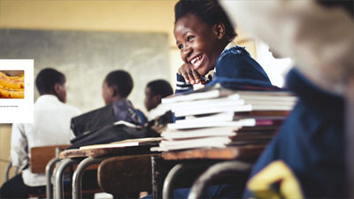 flicka som ler medan hon sitter i skolan