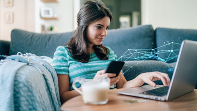 garota com notebook e smartphone na mão