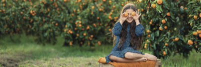 Girl with oranges over her eyes