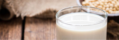 Glass with soya beverage on wooden table
