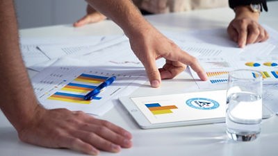 Reports, graphs and tablet on table