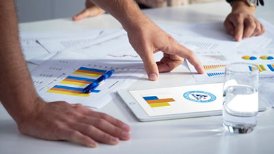 Reports, graphs and tablet on table