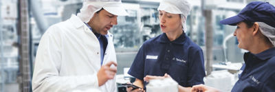 Three workers talking together in a lab