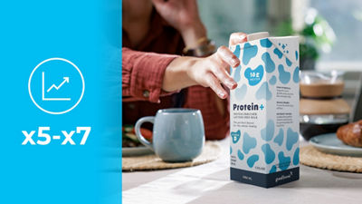 Pegando uma embalagem cartonada Tetra Brik Aseptic com leite proteico, ícone aumenta x5-x7