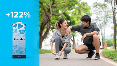 Para tuż przed rozpoczęciem joggingu w lesie, karton Tetra Prisma Aseptic z napojem proteinowym