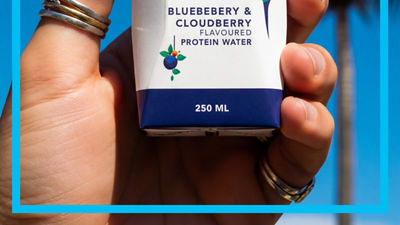 Hand with bottom of a nutrition drink.