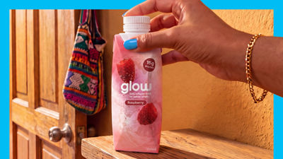 Hand holding glow drink in Tetra Prisma Aseptic carton package