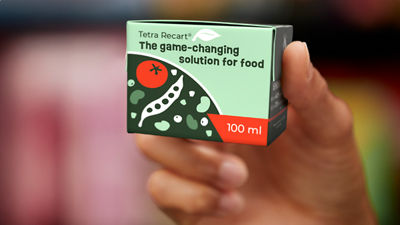 mano sosteniendo un envase recart pequeño de 100 ml