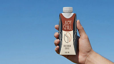 Hand holding Tetra Prisma Aseptic carton with ice coffee