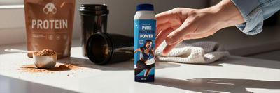 Hand reaching for protein drink in Tetra Prisma Aseptic carton