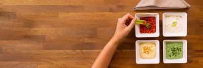 Hand dipping celery in 4 dips