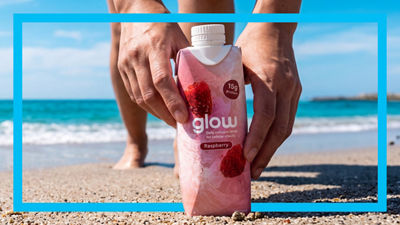 Hands holding glow drink in Tetra Prisma Aseptic carton