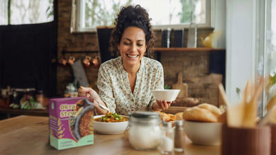 Femme préparant un repas dans une cuisine, plats préparés en briques Tetra Recart