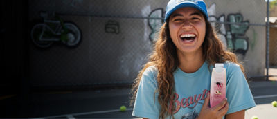 Mujer bebiendo té para llevar, envase Tetra Prisma Aseptic