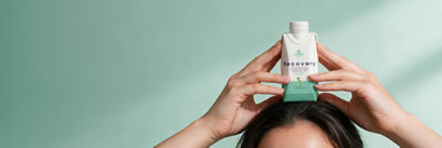 Holding recovery drink in Tetra Prisma carton on the head