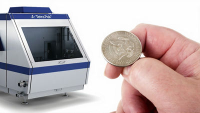 El homogeneizador Tetra Pak 250 y una mano que muestra 50 centavos