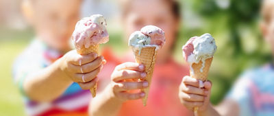 3 kids holding out their ice cream cones
