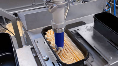 Closeup of nozzle filling up ice cream in a package