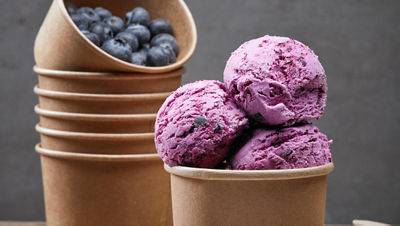 purple icecream in brown cups with bluberries in another cup