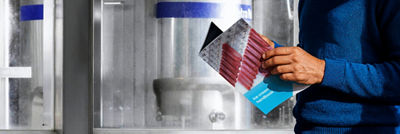 Person holding ice cream carton package in industrial setting