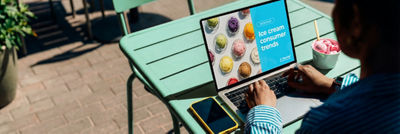 Person using digital screen to select ice cream products outdoors