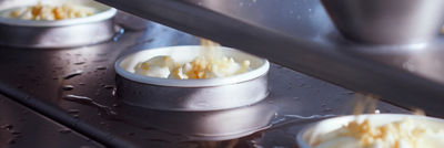 Containers filled with ice cream moving along an automated production line.