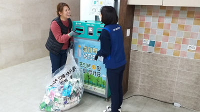 Women interacting in front of a carton recycling station