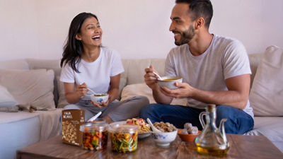 Happy people eating, salad and beans in Tetra Recart carton package