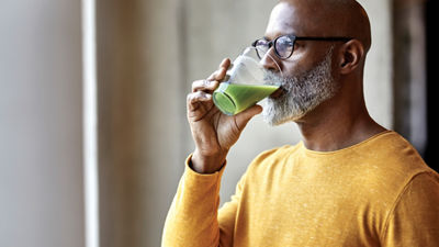 hombre bebiendo jugo verde