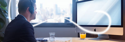 Man with headphones in front of computer display