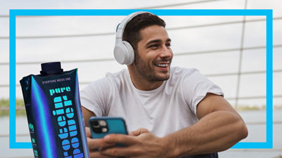 Homem com fones de ouvido e embalagem cartonada Tetra Prisma Aseptic