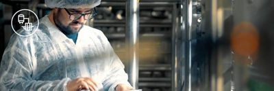 Man in white coat and hair net looking at ipad white smart production icon