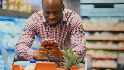 Man with smartphone in grocery store