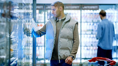 Man in grocery store shopping chilled dairy products