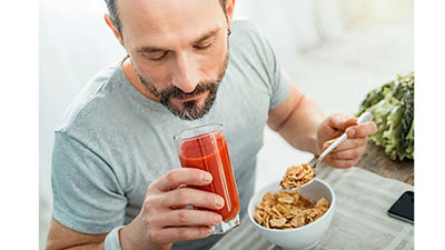 Man eating breakfast and drinking juice