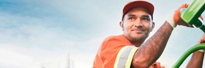 Man on the back of rubbish collection truck