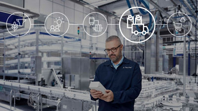 Une homme portant des lunettes inspecte un emballage dans une usine d'emballage