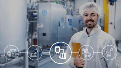 Man with hairnet and hazmat suit standing with ipad in factory