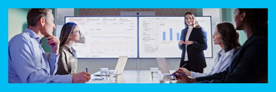 Personas reunidas en una oficina, datos en grandes pantallas